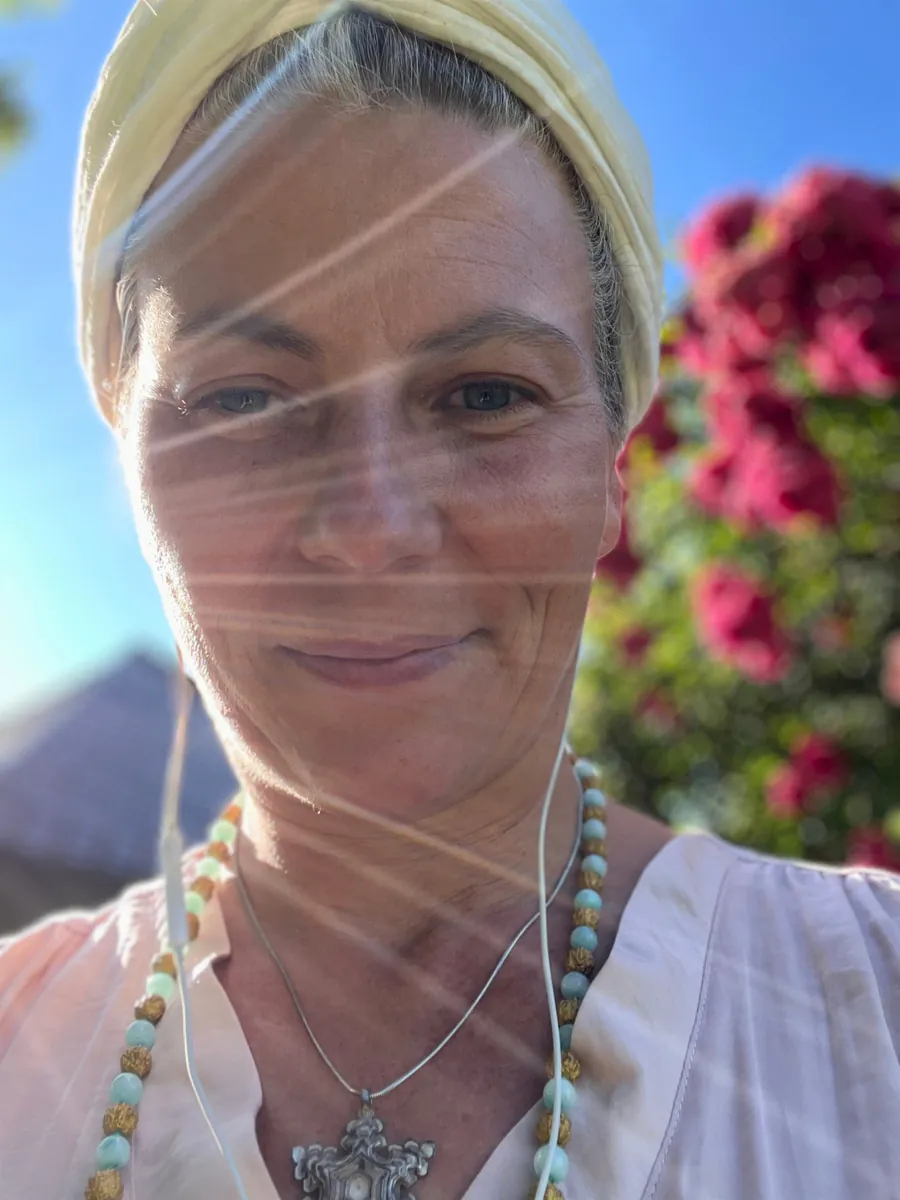 Sandra Hirsch bei einer Meditation im Freien mit Mala und Tuch